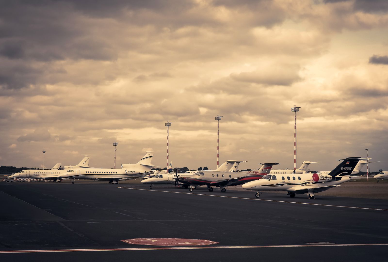 A line of private jets parked on the tarmac